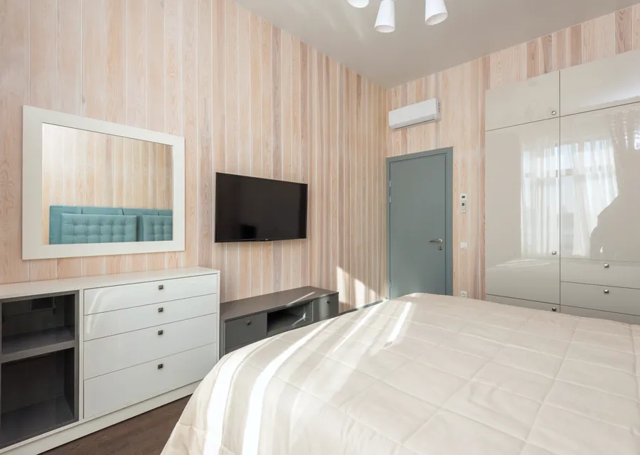 Bedroom with a compact wall-mounted air-conditioning unit