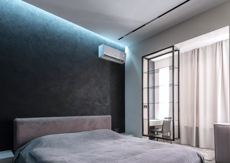 A stylish bedroom with a wall split on a dark feature wall
